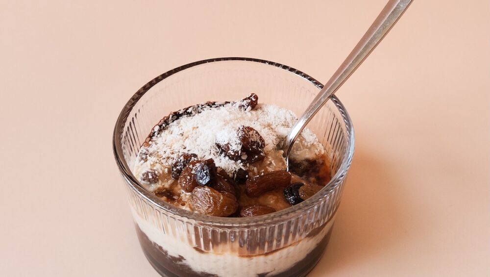 Chocolade vanille rijst toetje met rozijnen en kokosrasp in glazen dessertbakje. Gemaakt met 77greenfit.