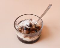 Chocolade vanille rijst toetje met rozijnen en kokosrasp in glazen dessertbakje. Gemaakt met 77greenfit.