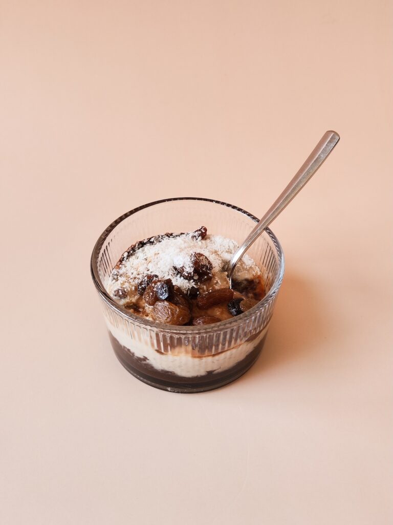 Chocolade vanille rijst toetje met rozijnen en kokosrasp in glazen dessertbakje. Gemaakt met 77greenfit.